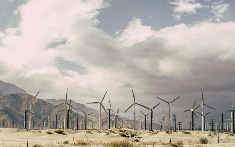 Wind turbines against dramatic desert landscape, promoting sustainable energy solutions.