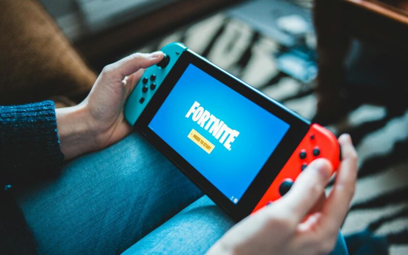 Un copil care se joaca pe o consola portabila Nintendo Switch