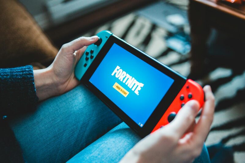 Un copil care se joaca pe o consola portabila Nintendo Switch