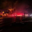 fire truck beside burning house during nighttime