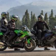 doua motociclete kawasaki la margine de drum muntos cu padure in spate