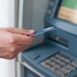 o femeie foloseste un bancomat