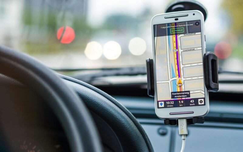 aplicatia google maps ruland pe un telefon pozitionat in suportul de masina