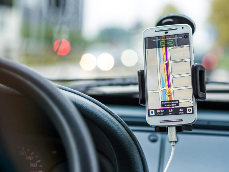 aplicatia google maps ruland pe un telefon pozitionat in suportul de masina