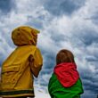 Copii care privesc spre o furtună pe fondul schimbărilor climatice