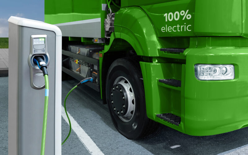 un camion electric langa o statie de incarcare