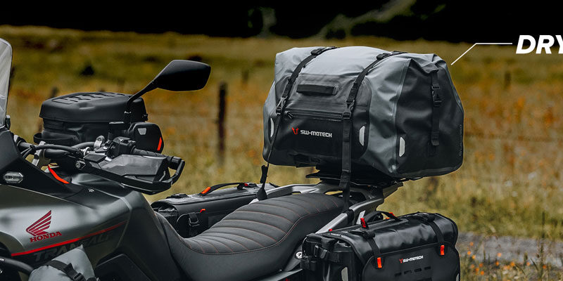 motocicleta offroad cu bagaje aditionale fotografiata pe un drum de tara
