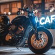 motocicleta benda de tipul chopper fotografiat in fata unei firme luminoase