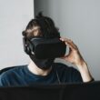 om care sta in fata unui calculator purtand ochelari VR