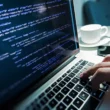 un programator lucreaza la laptop