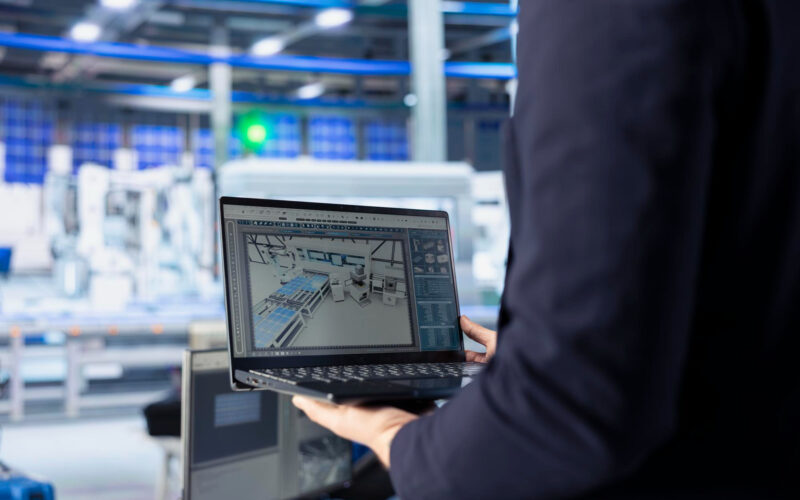 un angajat foloseste un laptop intr-o fabrica