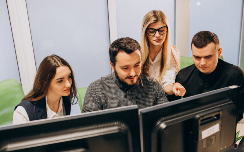mai multi oameni se uita la monitoare