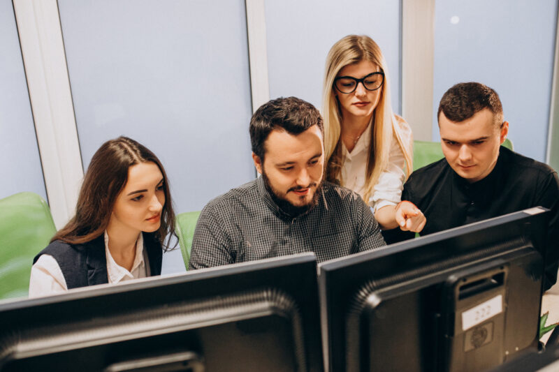 mai multi oameni se uita la monitoare