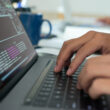 un programator scrie cod la un laptop