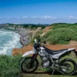 motocicleta adventure kwasaki fotografiata la malul unui ocean