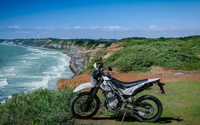 motocicleta adventure kwasaki fotografiata la malul unui ocean