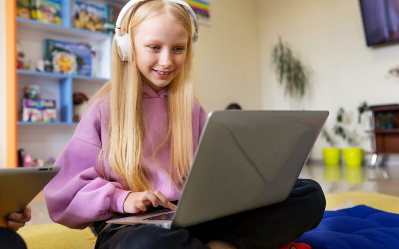 o fetita foloseste un laptop