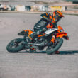 motocicleta ktm portocalie de tipul supermoto inclinata pe partea dreapta pe circuit