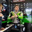 pilot de curse de motociclete fotografiat la stand inbracat in combinezon verde