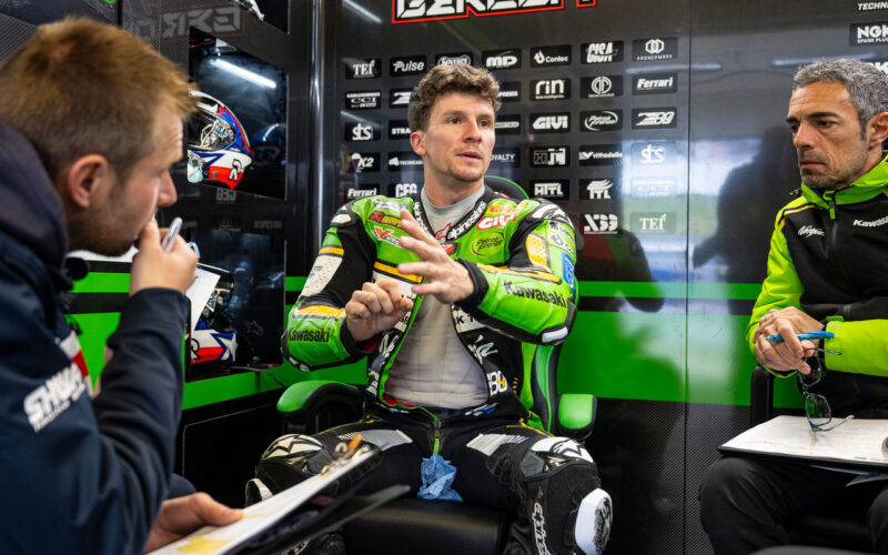pilot de curse de motociclete fotografiat la stand inbracat in combinezon verde