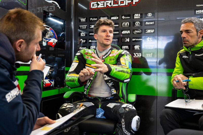 pilot de curse de motociclete fotografiat la stand inbracat in combinezon verde