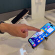 un barbat testeaza un iphone intr-un magazin