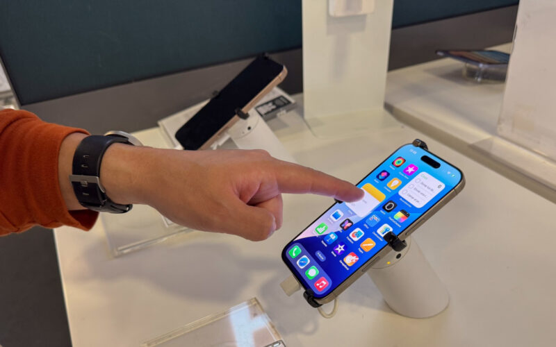 un barbat testeaza un iphone intr-un magazin