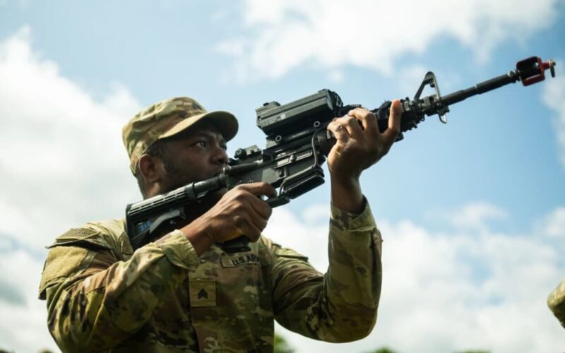 un soldat care tine in mana o arma echipata cu o luneta inteligenta care ajuta la doborarea dronelor
