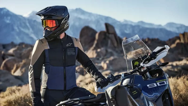 motociclist echipat alaturi de motocicleta lui adventure la poalele muntelui