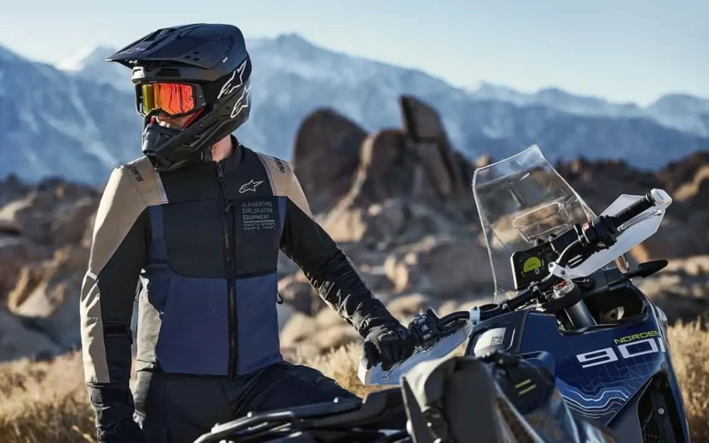 motociclist echipat alaturi de motocicleta lui adventure la poalele muntelui