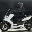 scuter alb cu un rider imbracat in negru surprins noatea