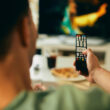 un barbat foloseste o telecomanda tv