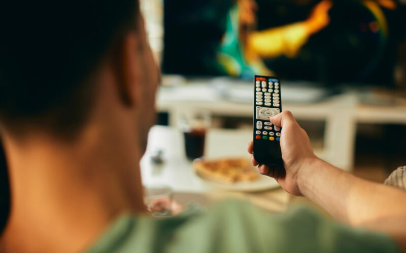 un barbat foloseste o telecomanda tv