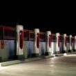 A row of Tesla charging stations illuminated at night in Redlands, CA.