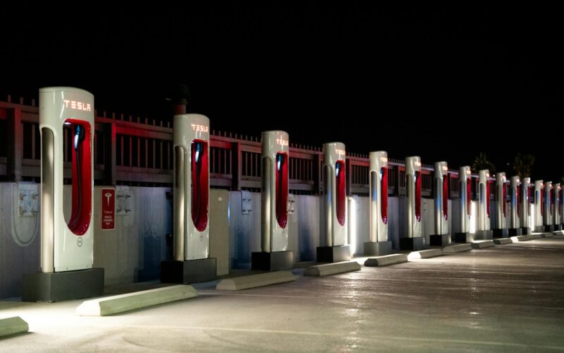 A row of Tesla charging stations illuminated at night in Redlands, CA.