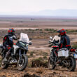 doua motociclete off-road fotografiate pe drum accidentat