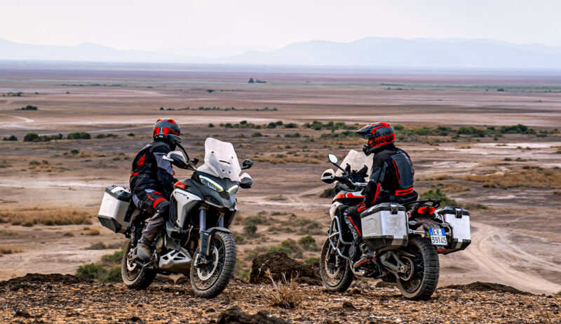 doua motociclete off-road fotografiate pe drum accidentat