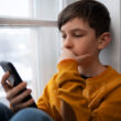 un copil foloseste un smartphone