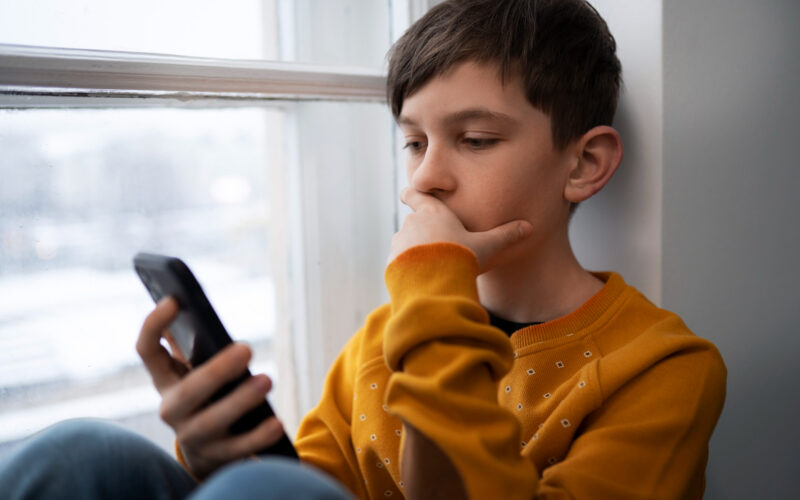 un copil foloseste un smartphone