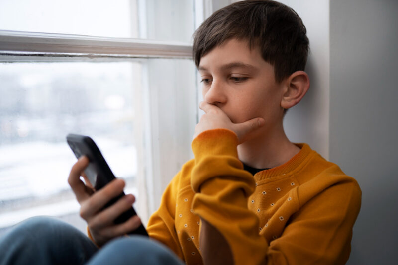 un copil foloseste un smartphone