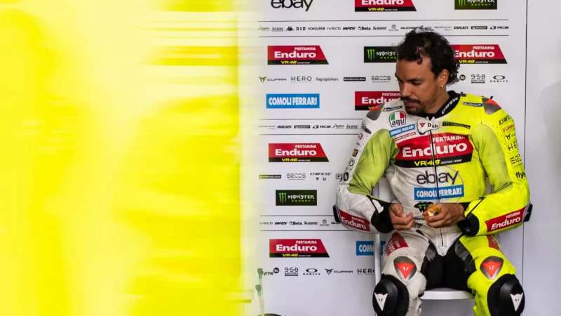 pilot de curse motogp fotografiat la boxe echipat complet in combinezon de culoare galbena