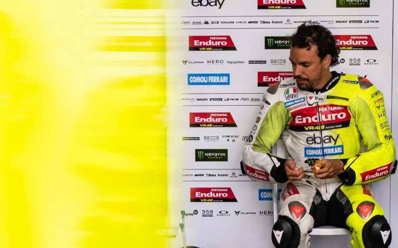 pilot de curse motogp fotografiat la boxe echipat complet in combinezon de culoare galbena