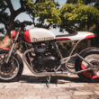 motocicleta custom made la triumph fotografiata cu copaci in spate