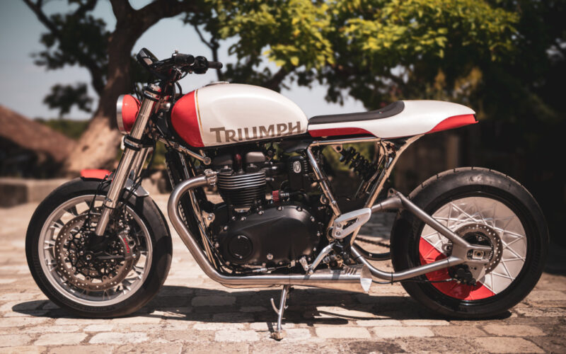 motocicleta custom made la triumph fotografiata cu copaci in spate