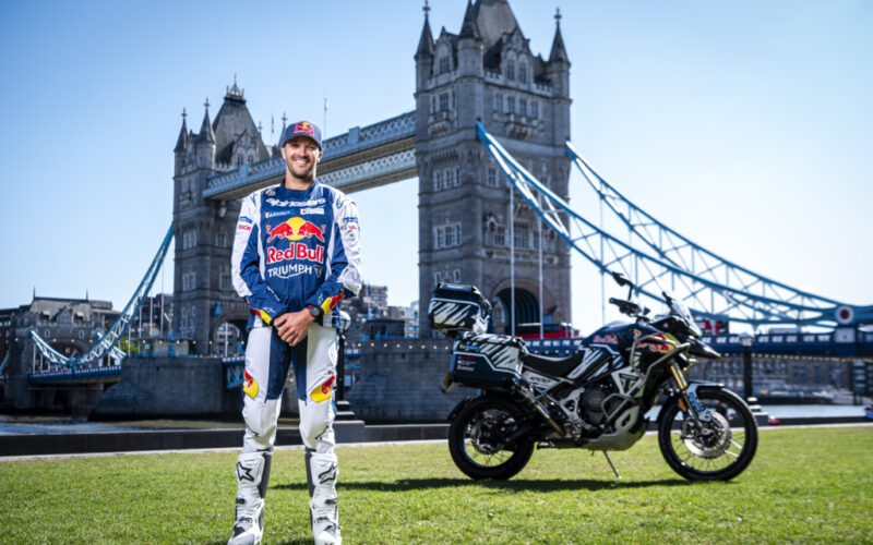 pilot moto alaturi de motocicleta sa la poalele podului din anglia