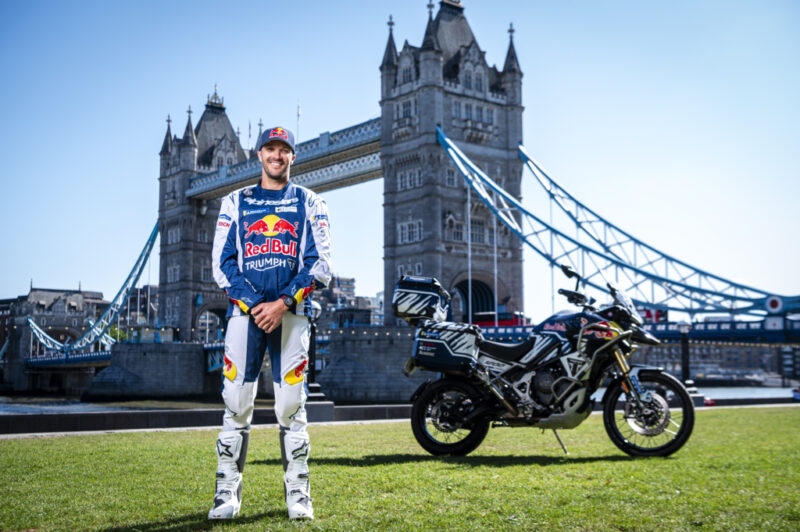 pilot moto alaturi de motocicleta sa la poalele podului din anglia