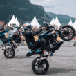 doua moto bmw pe o roata fotografiate pe o pista de concurs