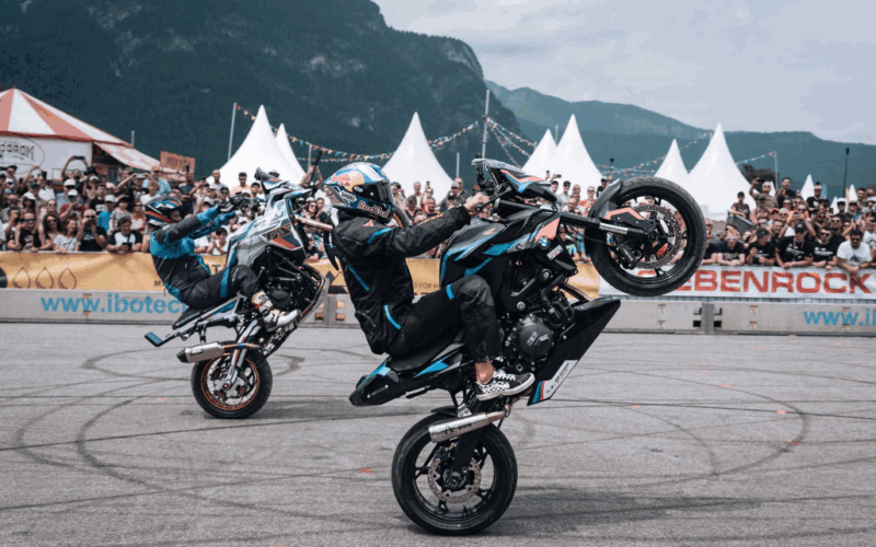 doua moto bmw pe o roata fotografiate pe o pista de concurs