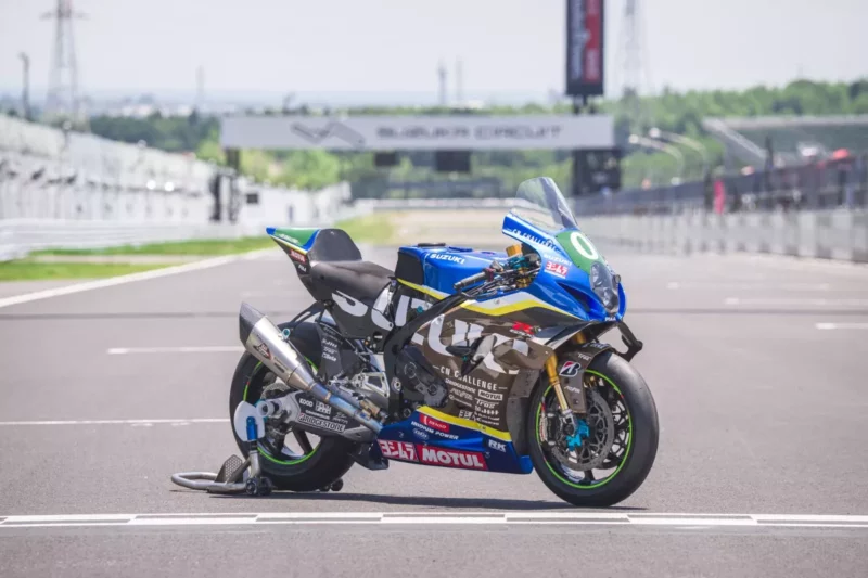 motocicleta suzuki de competitie in culoarea albastra fotografiata pe pista