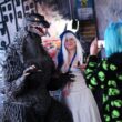 o fana costumata se pozeaza cu personajul Godzilla in cadrul conferintei comic 2025 con